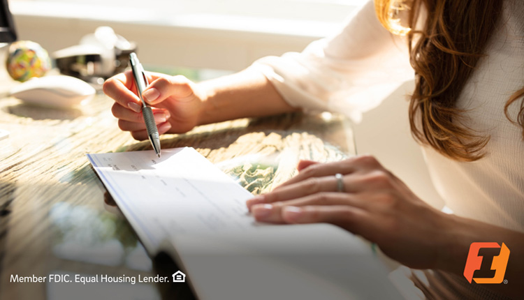 A woman holding a checkbook and pen